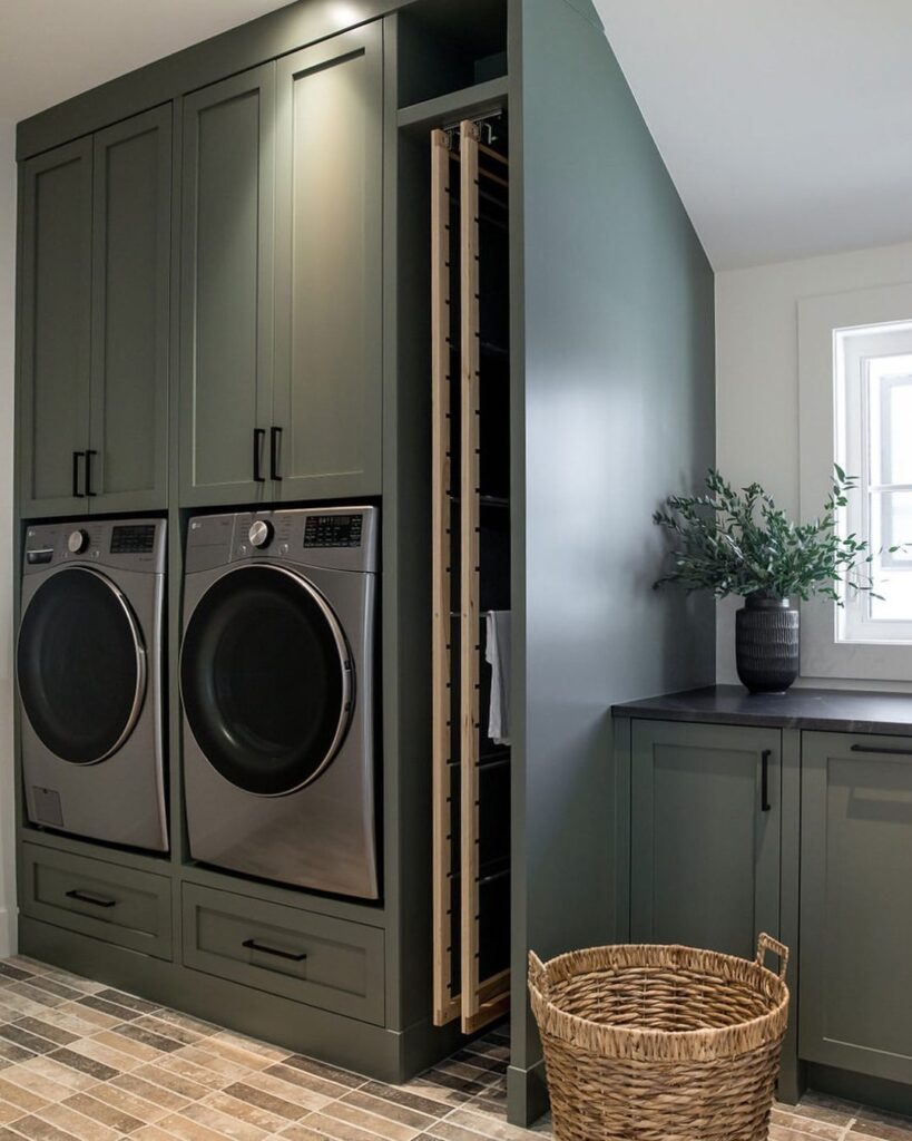 Modern laundry room with sage cabinets and hidden drying rack