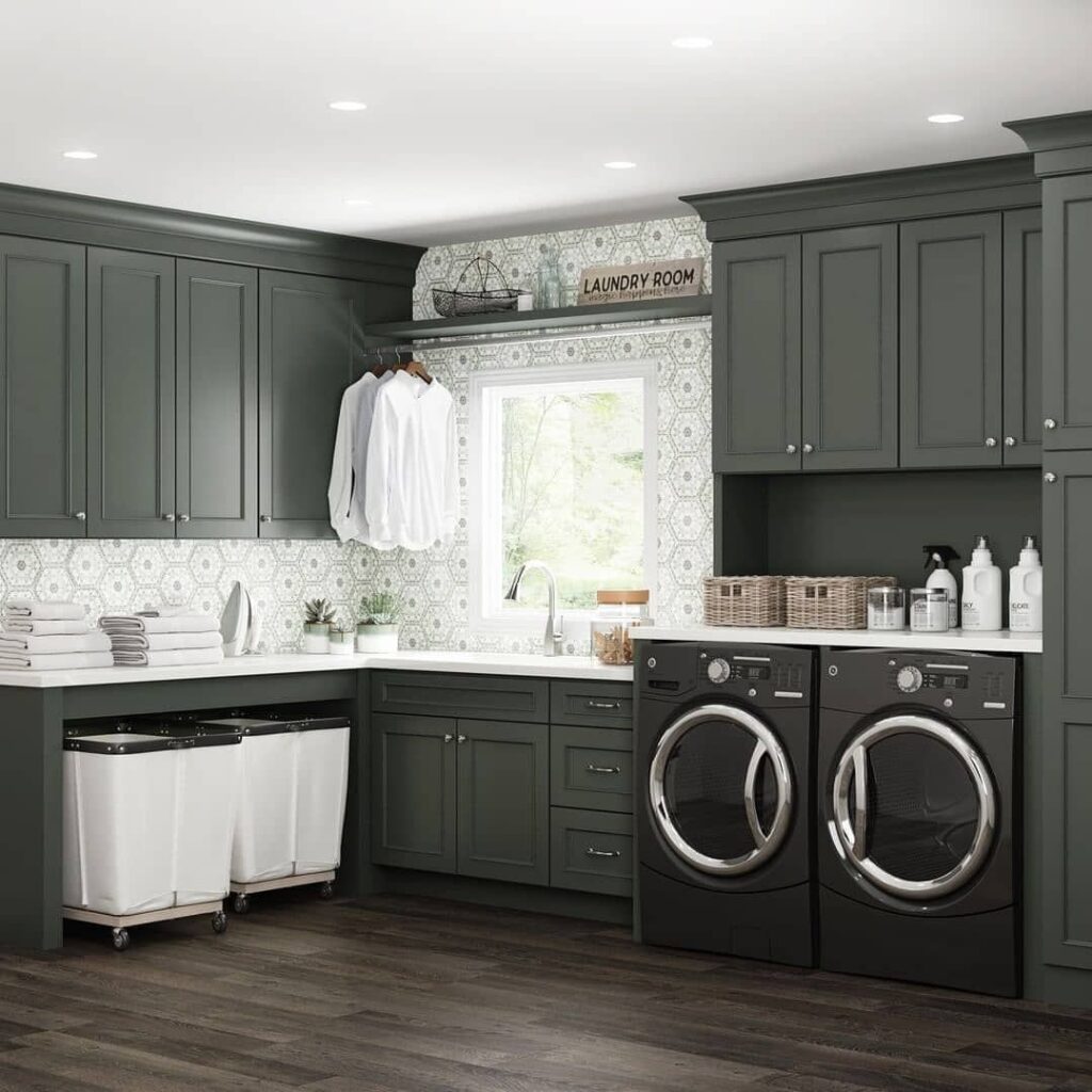 Elegant green laundry room with patterned backsplash and modern appliances.