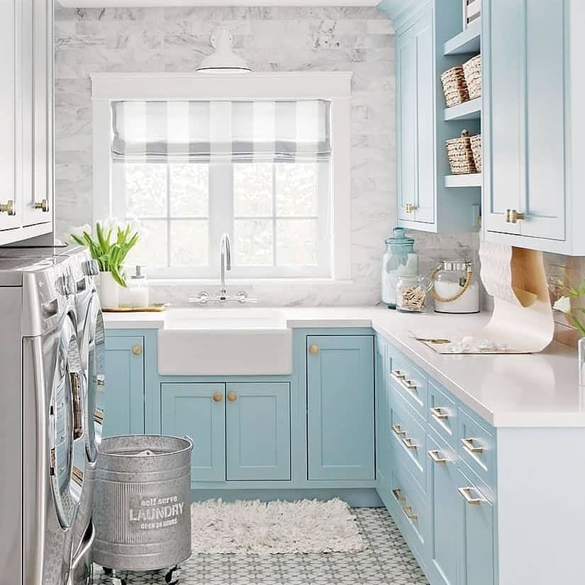 Blue and white laundry room with farmhouse sink and mosaic floor.