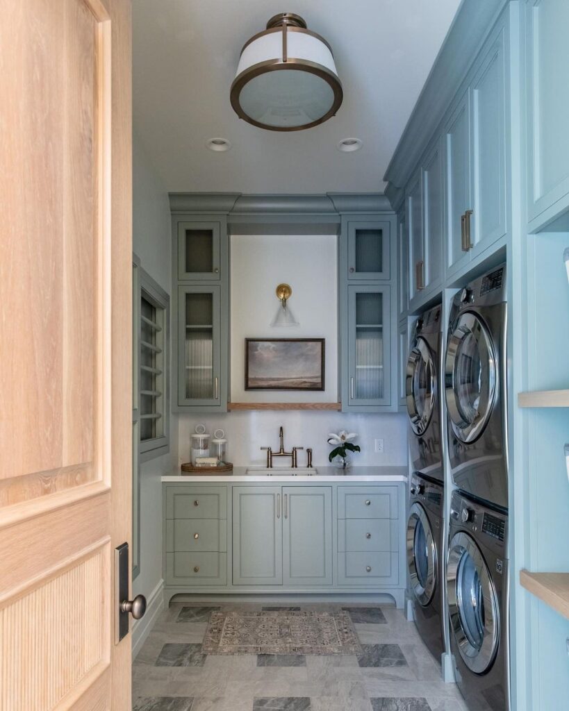 Elegant blue laundry room with stacked appliances and sink