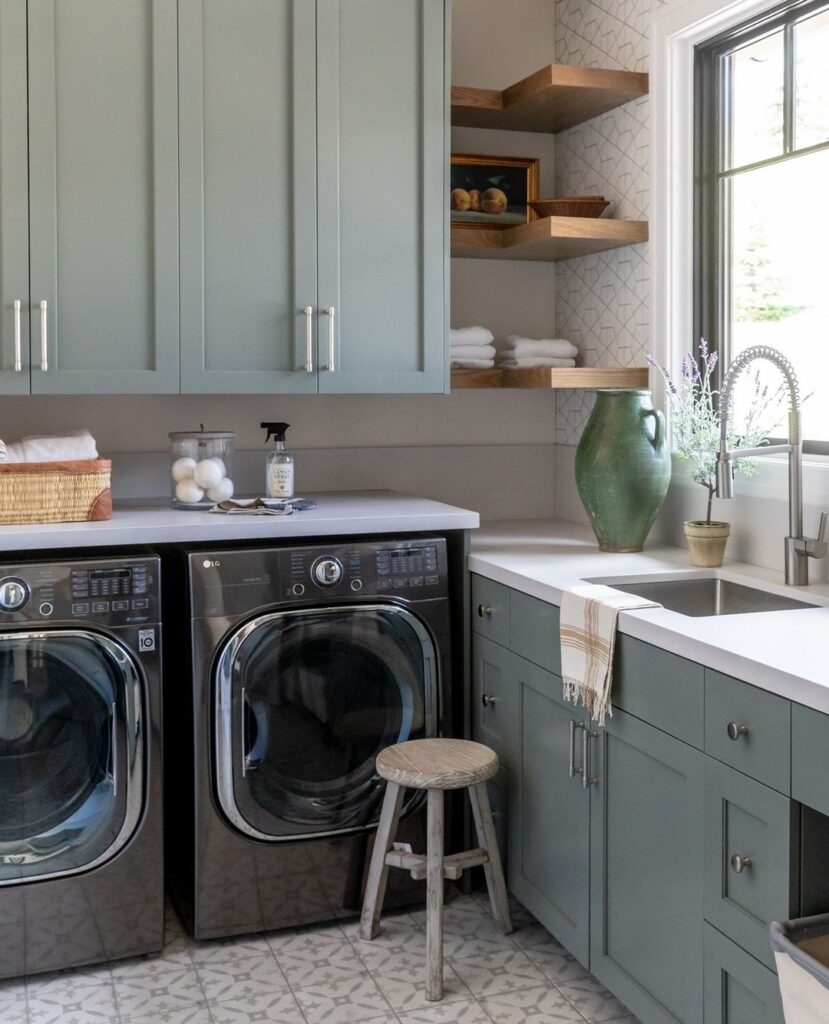 Elegant green laundry room with modern appliances.