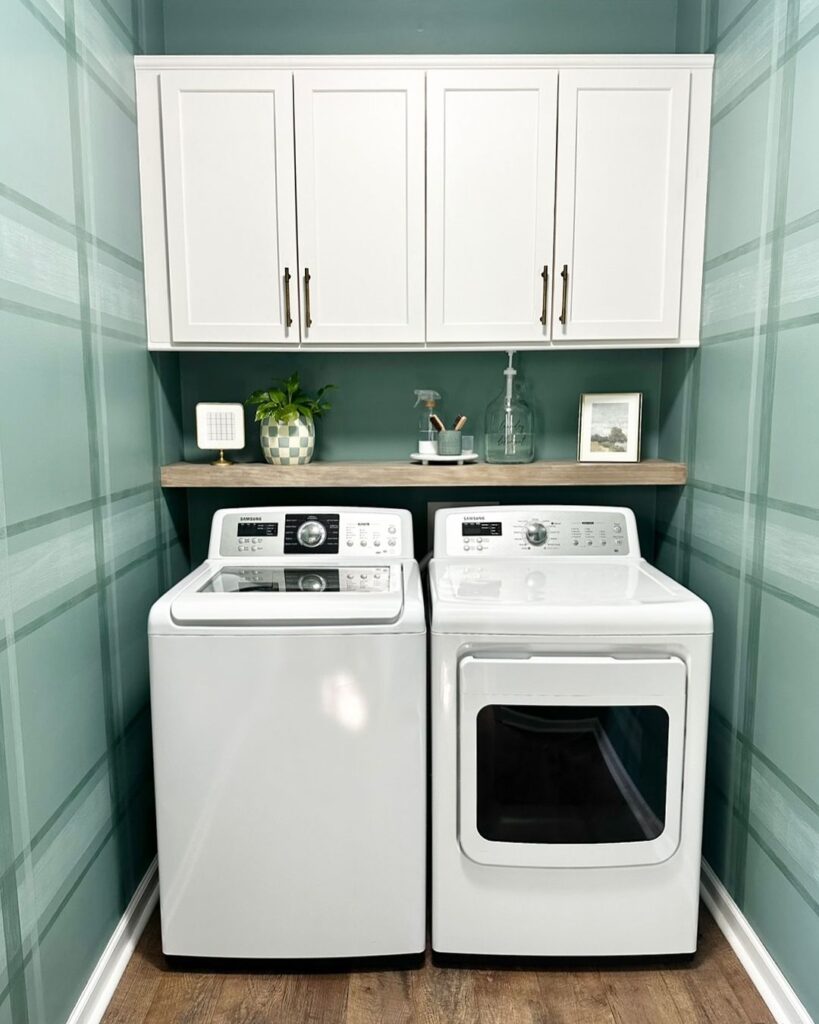 Mint green laundry nook with white appliances and cabinets