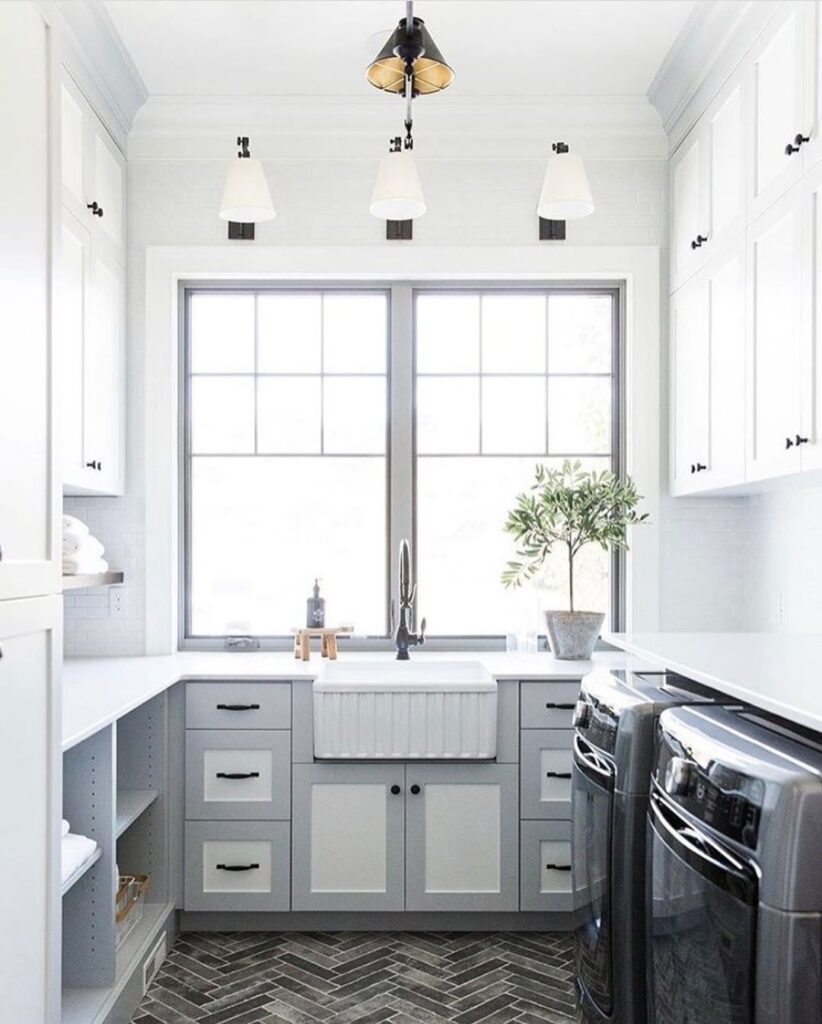 Bright laundry room with gray cabinets and farmhouse sink.