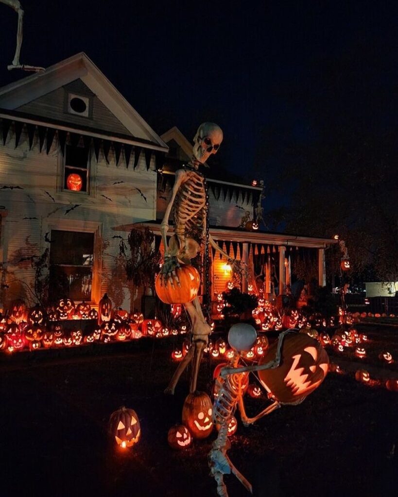 Giant skeletons amid glowing pumpkins Halloween house