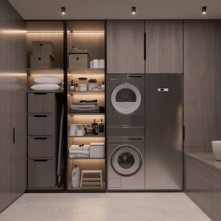 Modern gray laundry room with hidden storage and illuminated shelving.