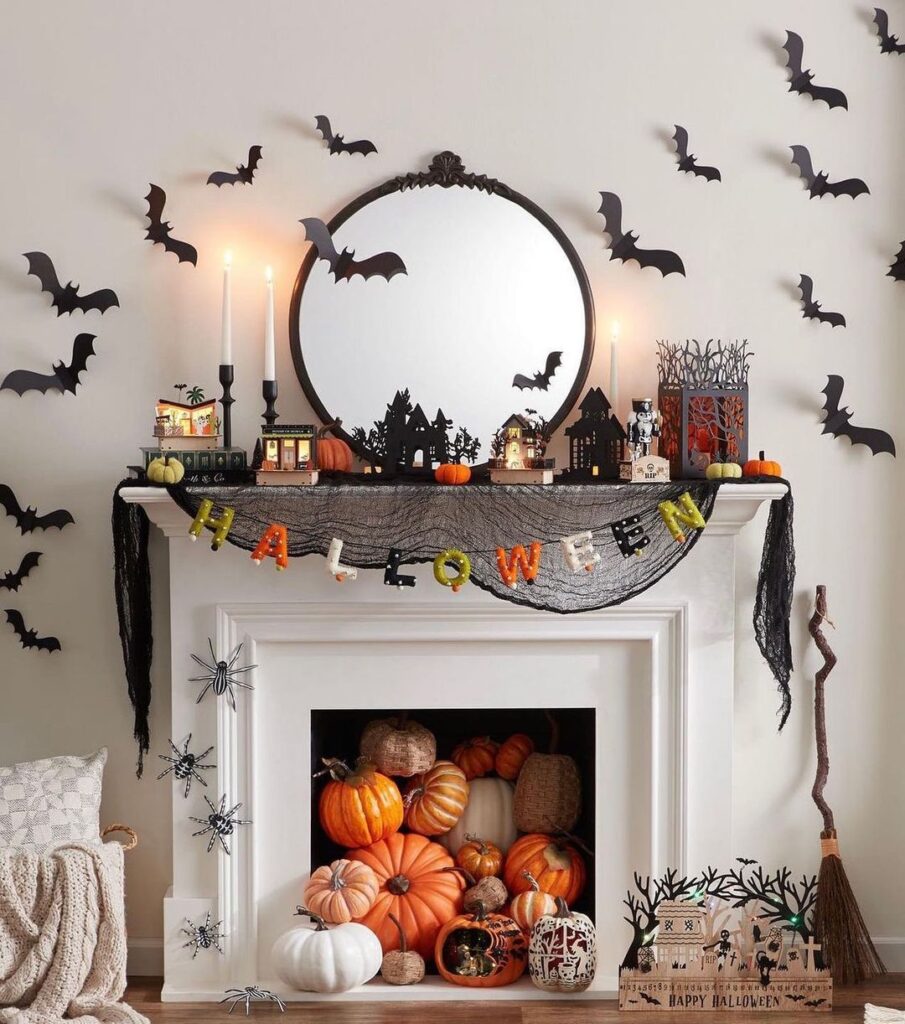 Halloween fireplace mantel decorated with bats pumpkins and haunted houses