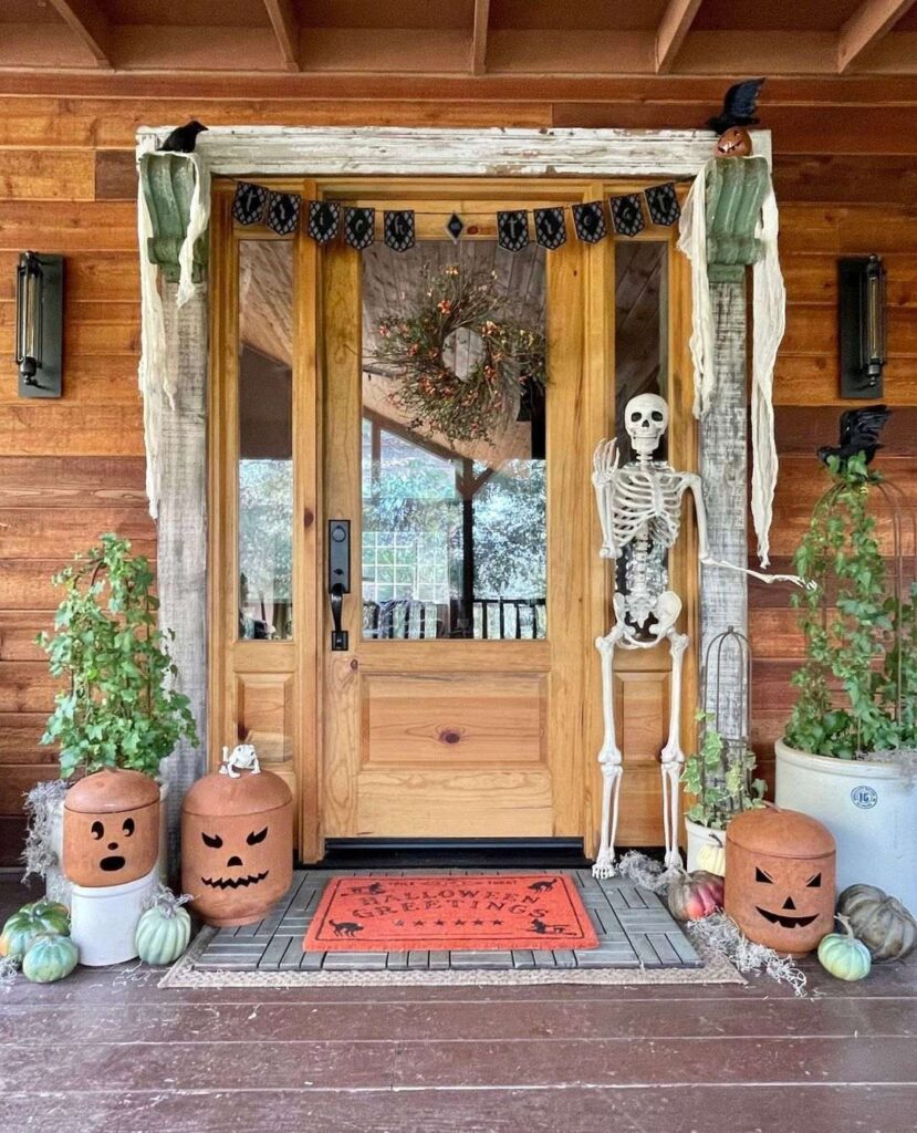 Halloween-decorated cabin entrance with skeleton and pumpkins