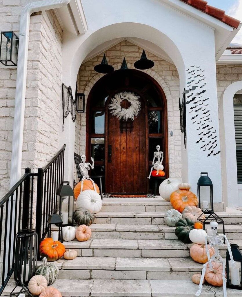 Halloween-themed porch with skeletons witch hats and pumpkins