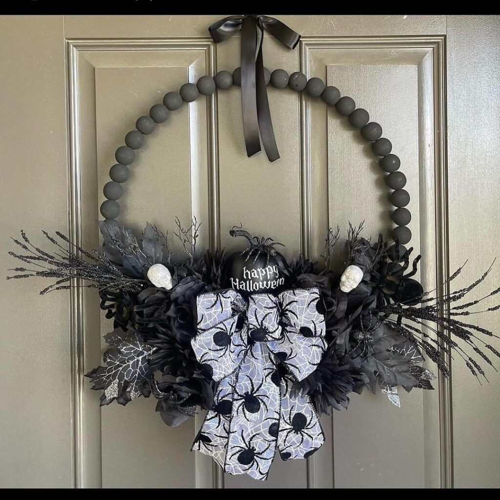 Gray and black Halloween wreath with spider web bow.