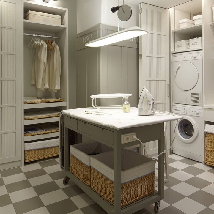 Laundry room with rolling ironing table and built-in storage.