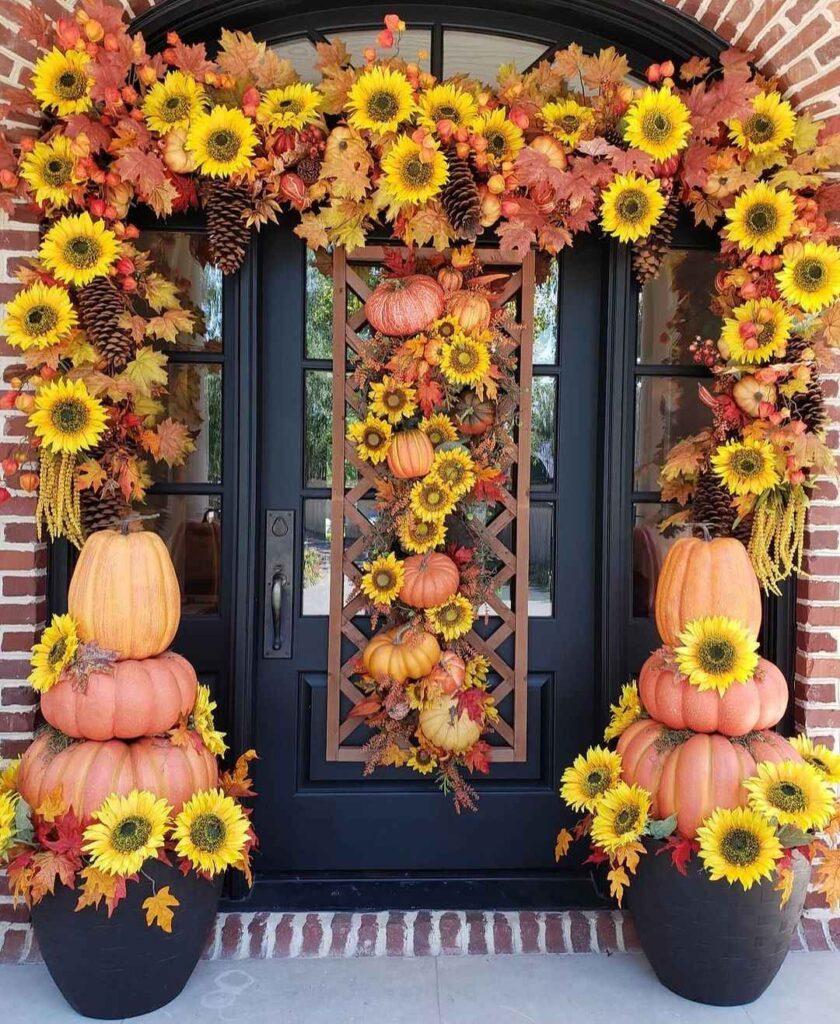 Doorway adorned with sunflowers pumpkins and fall leaves.