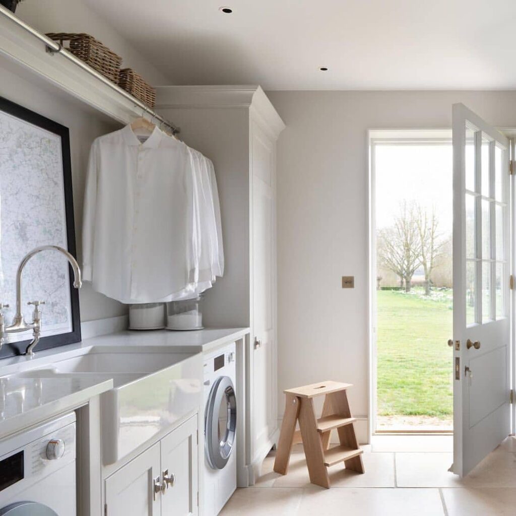 White laundry room with open French doors to garden view.