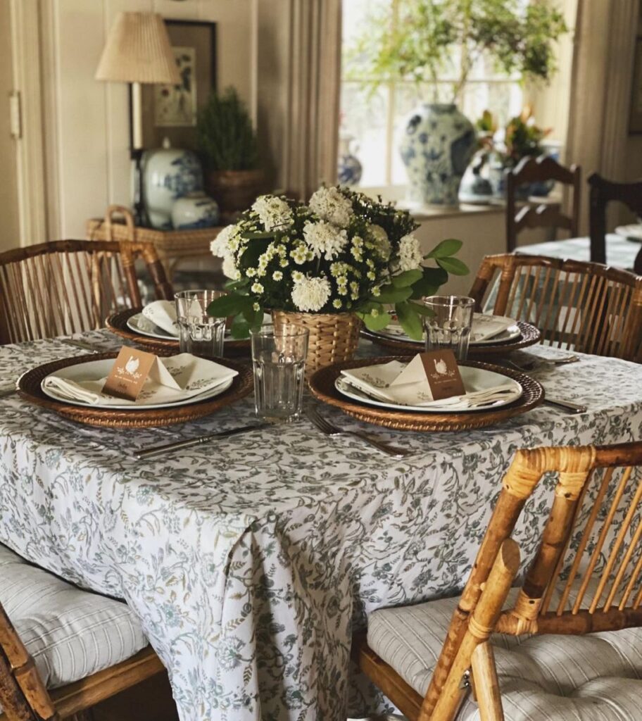 Thanksgiving table with white floral centerpiece and rattan chairs