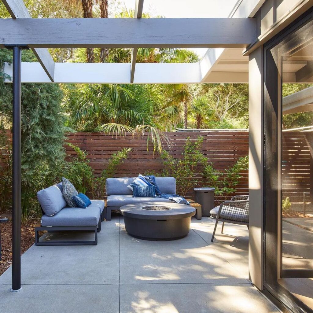 Modern patio with blue sofas and fire table