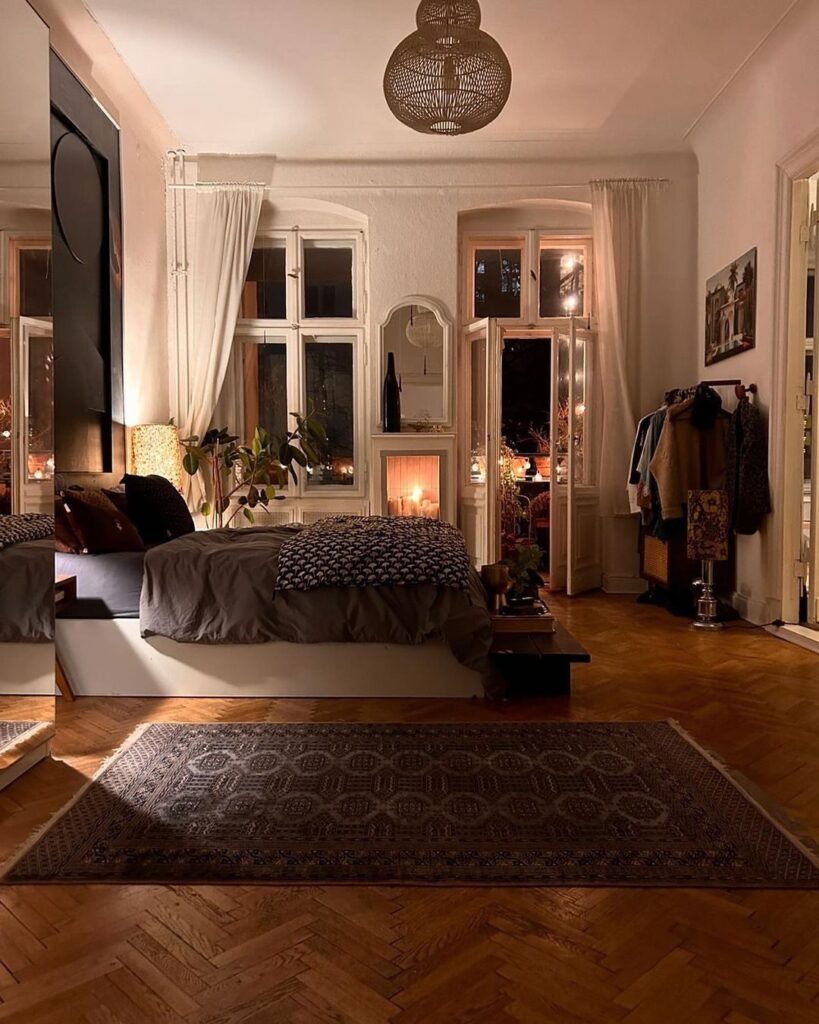 Cozy urban bedroom with candlelit ambiance large windows and eclectic decor