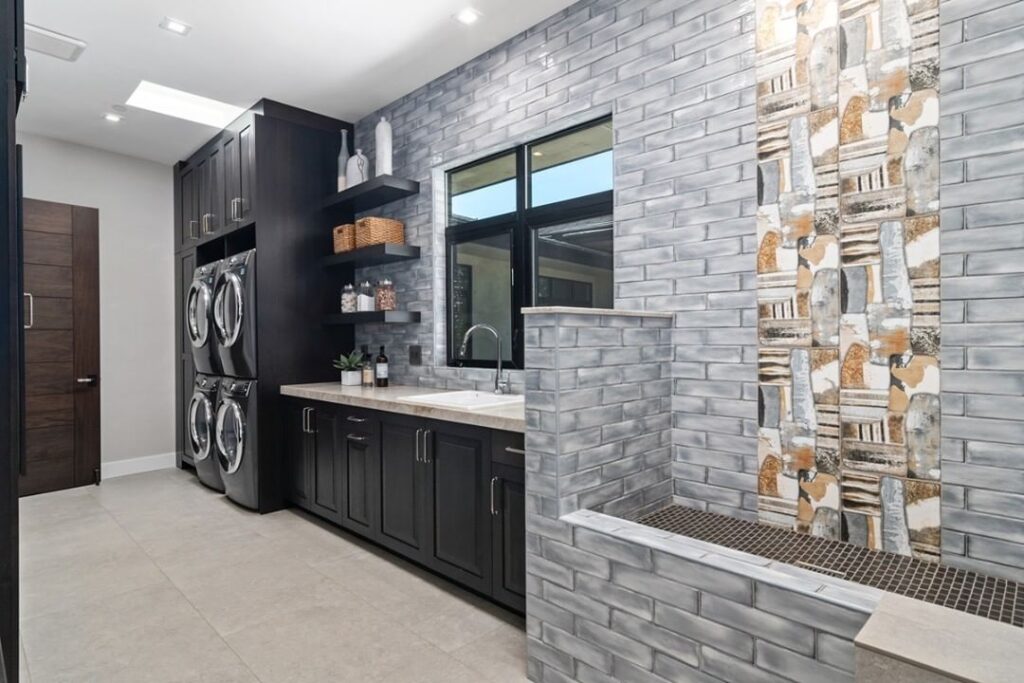 Modern laundry room with brick walls and dog wash area.