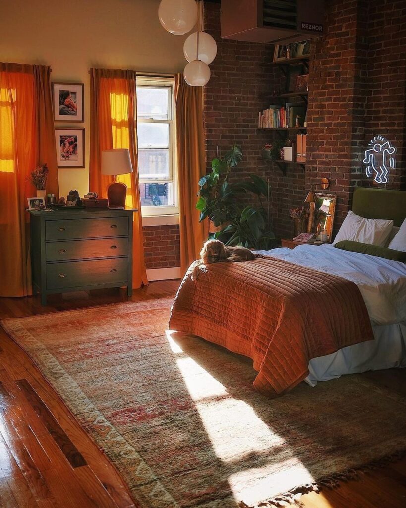 Cozy brick-walled bedroom with orange accents and warm sunlight