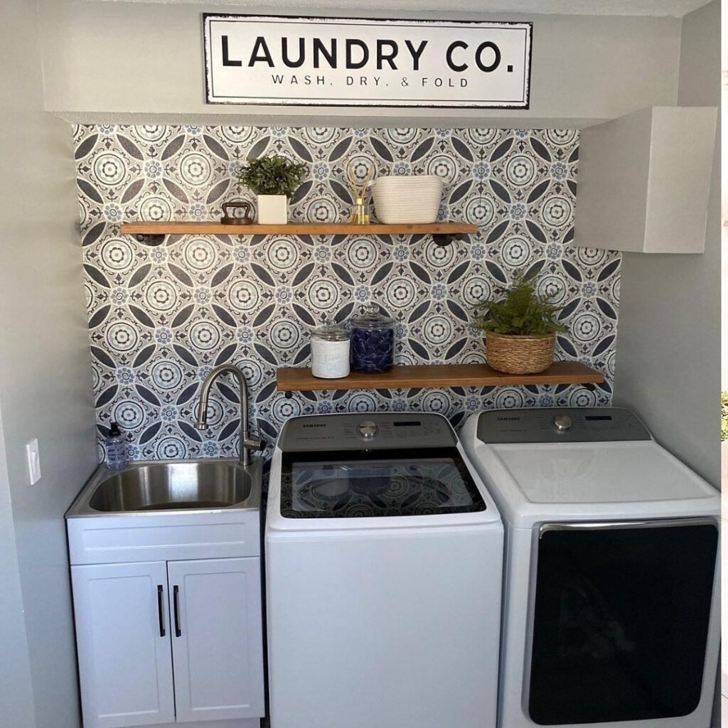 Laundry room with patterned wallpaper and modern appliances.