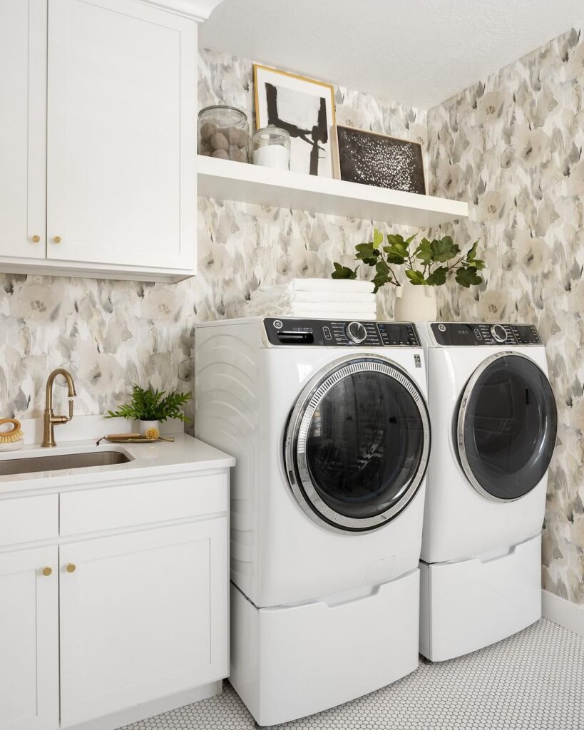 Laundry room with watercolor wallpaper and white appliances.