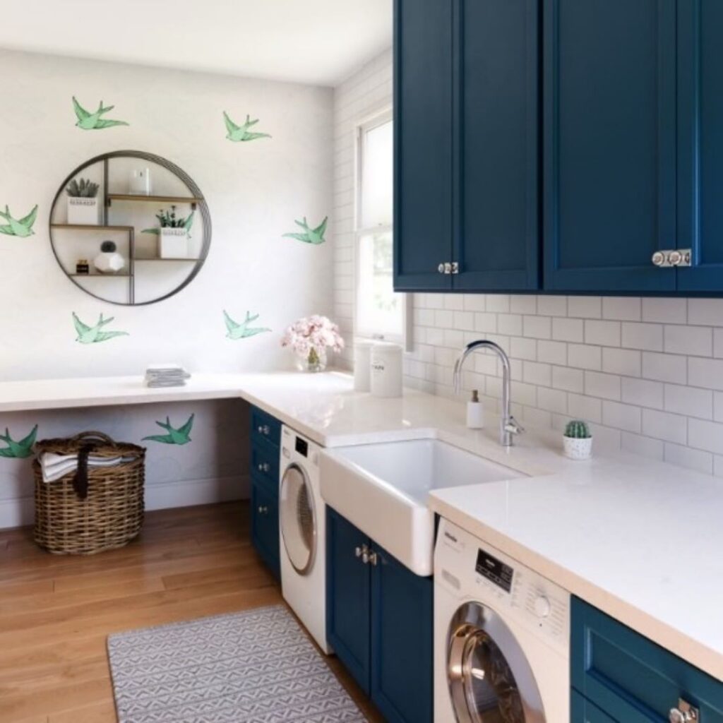 Navy and white laundry room with bird decals and modern appliances.