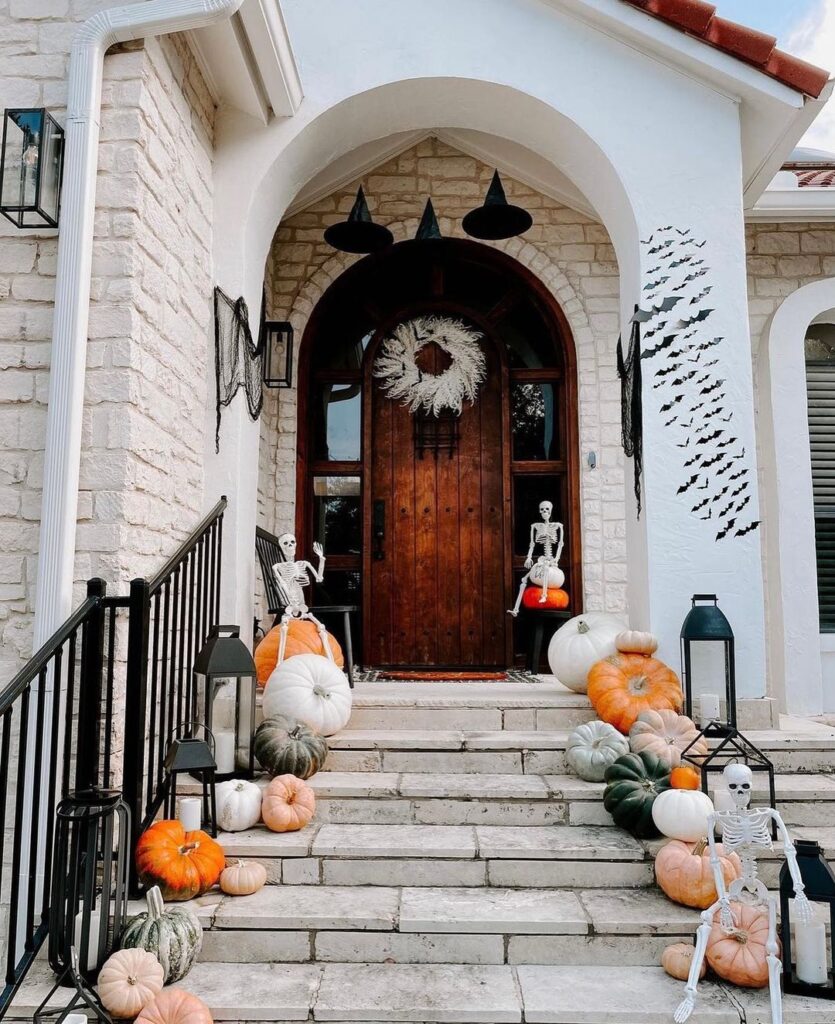 Halloween-decorated front porch with pumpkins and skeletons