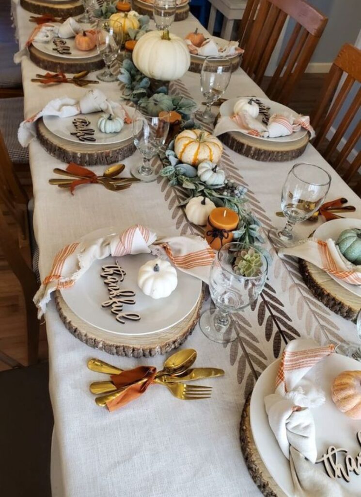 Thanksgiving table with pumpkins eucalyptus and wood slices