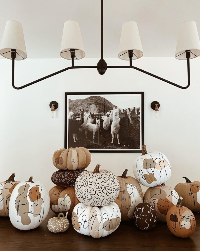 Collection of pumpkins decorated with abstract line art designs.