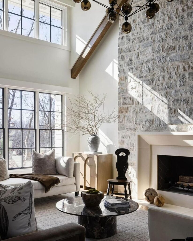 Bright living room with high ceilings stone wall and large windows