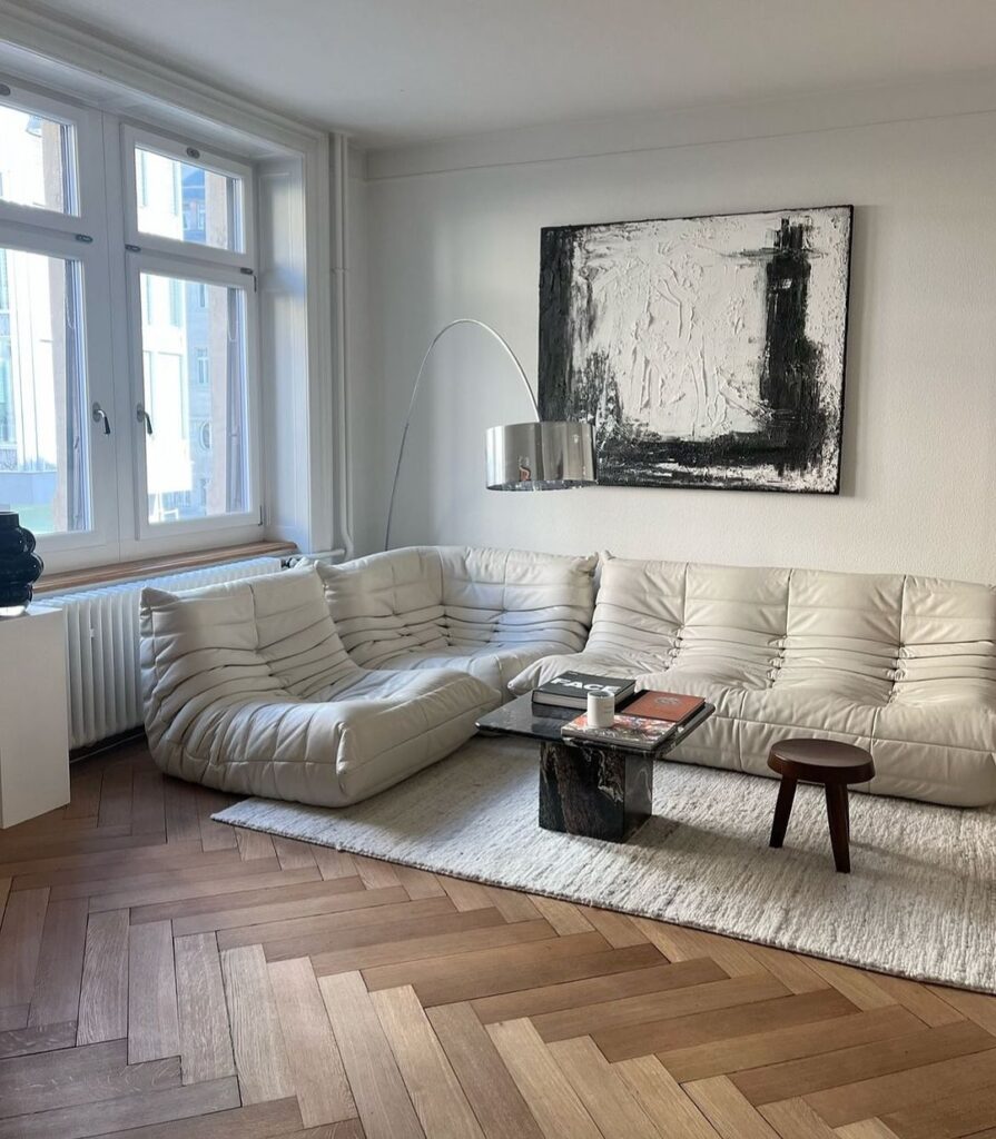 Modern living room with white sectional sofa and abstract art