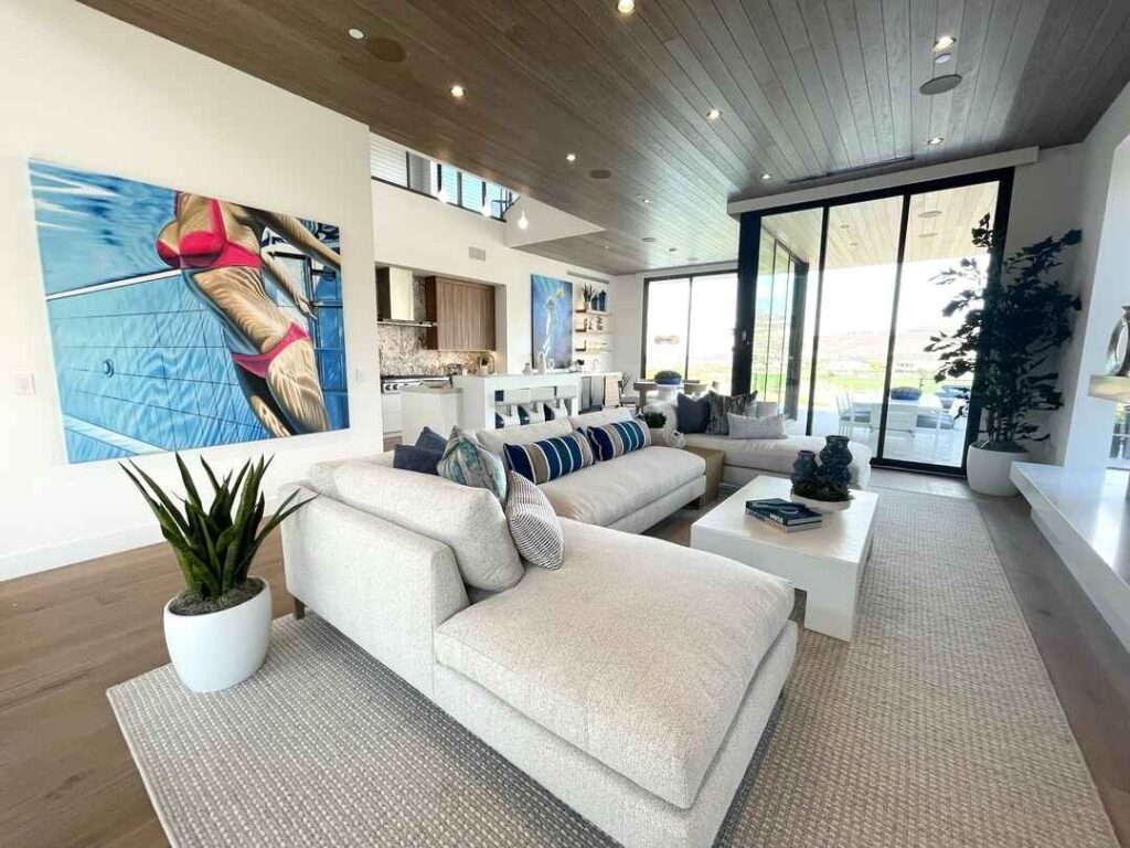 Bright coastal living room with large artwork and ocean view.