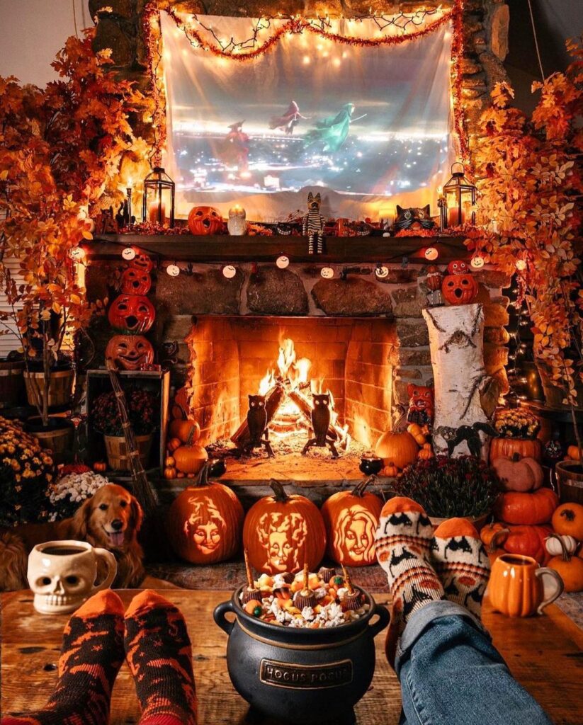 Halloween-decorated fireplace with pumpkins and movie screen