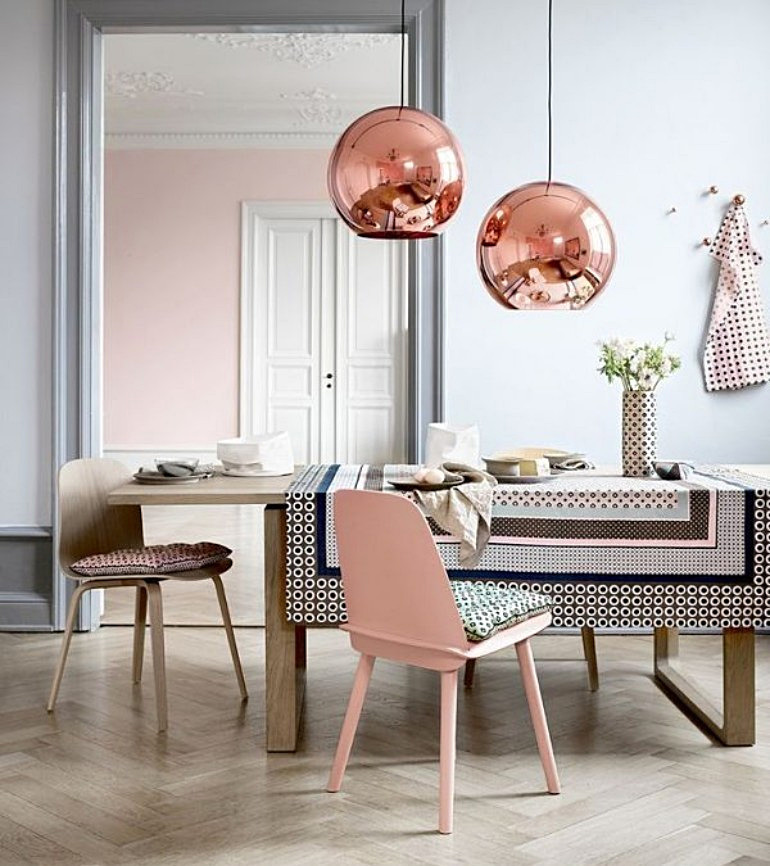 Modern dining space with copper pendant lights and pink accents