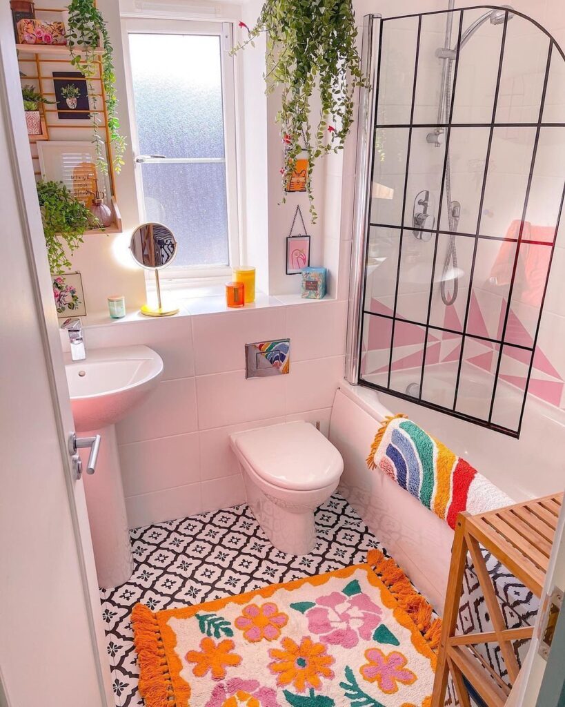 Pink bathroom with plants colorful rug and bohemian decor