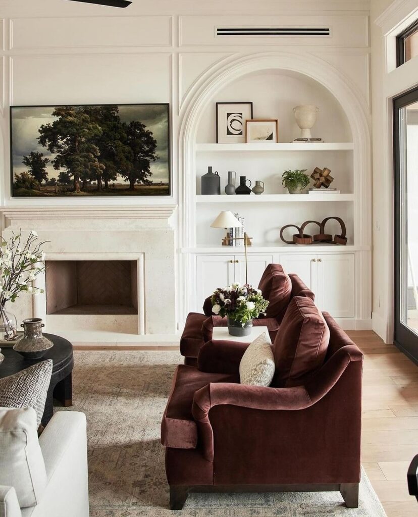 Elegant living room with white walls burgundy sofas and built-in shelving