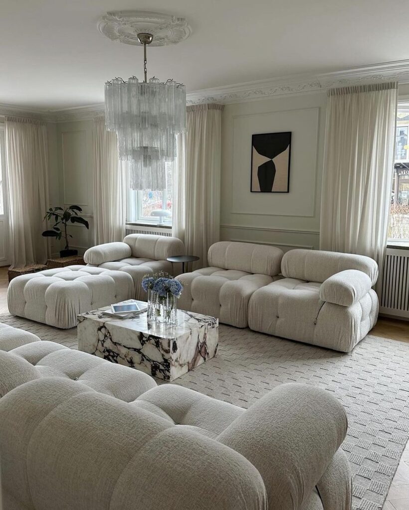 Luxurious white living room with puffy sofas and chandelier