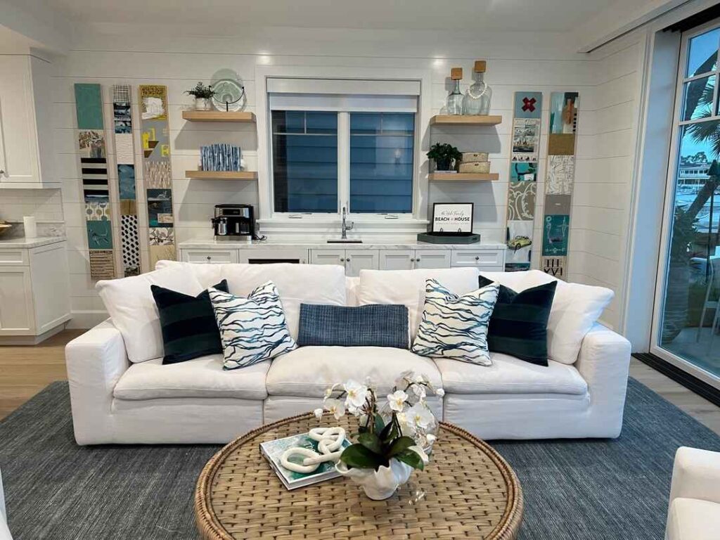 Beach-themed living room with white sofa and coastal decor.