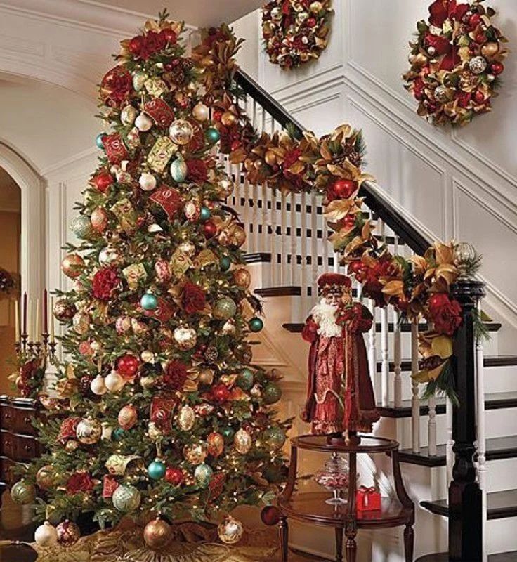 Burgundy and gold decorated Christmas tree with colonial style staircase and wreaths