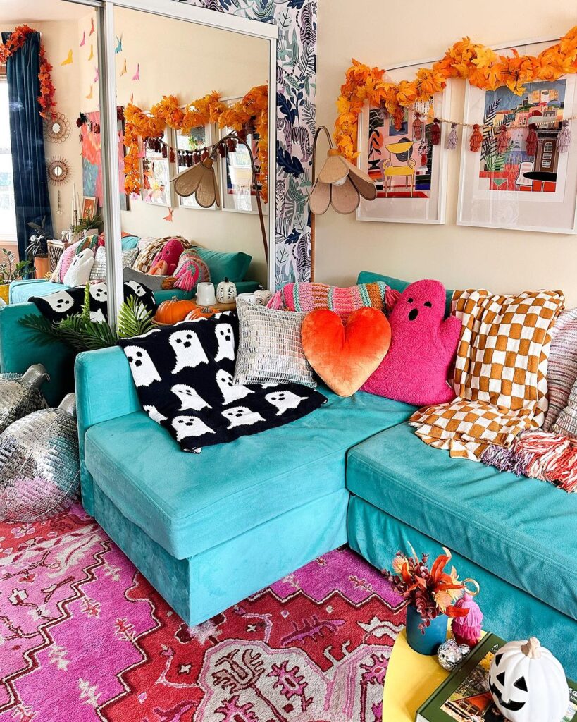 Teal couch with Halloween decor in colorful room.