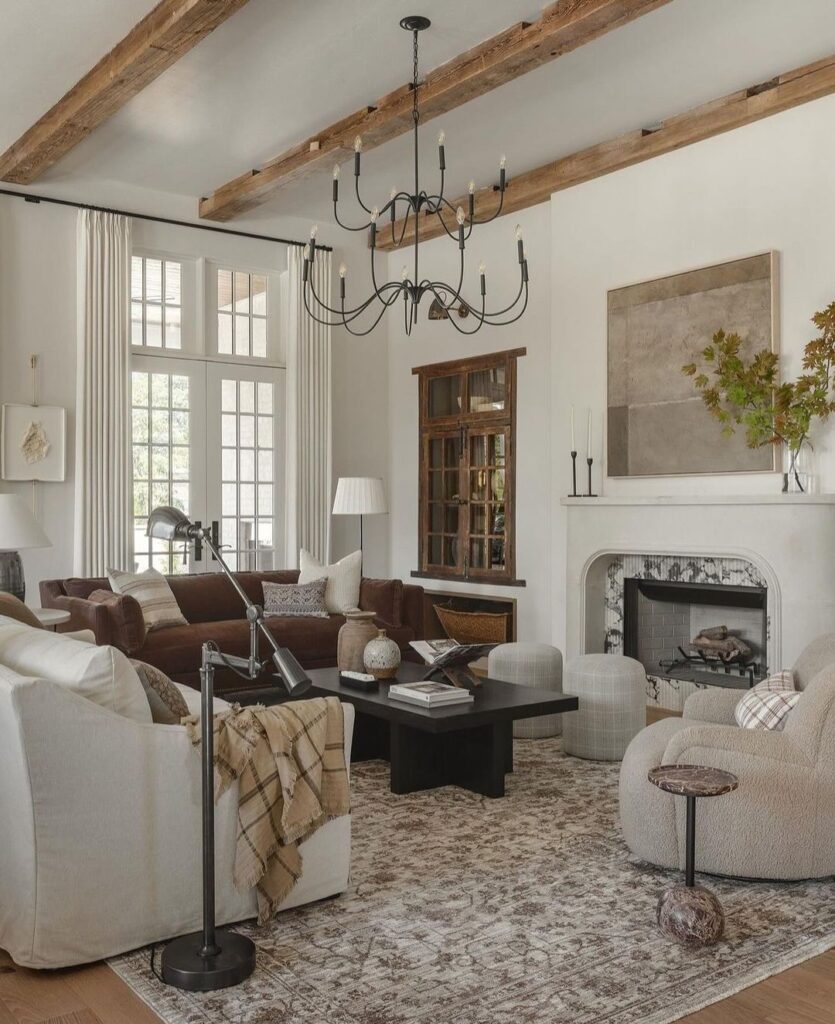 Living room with wooden beams chandelier fireplace and mixed seating