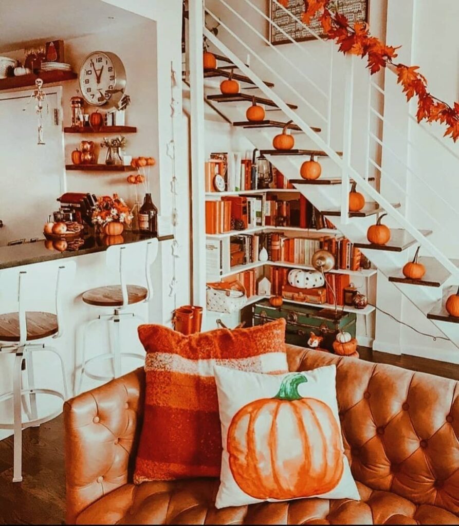 Autumnal living room with pumpkin-lined staircase and bookshelves