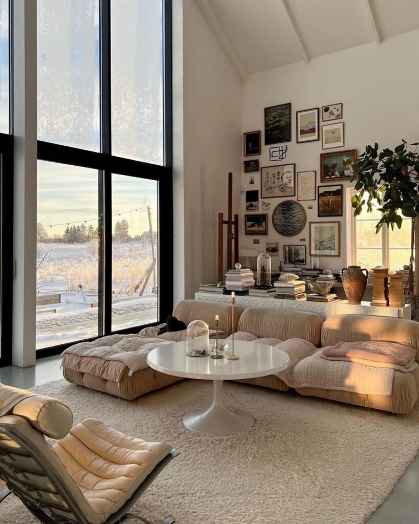 Sunlit living room with low seating art wall and snowy view