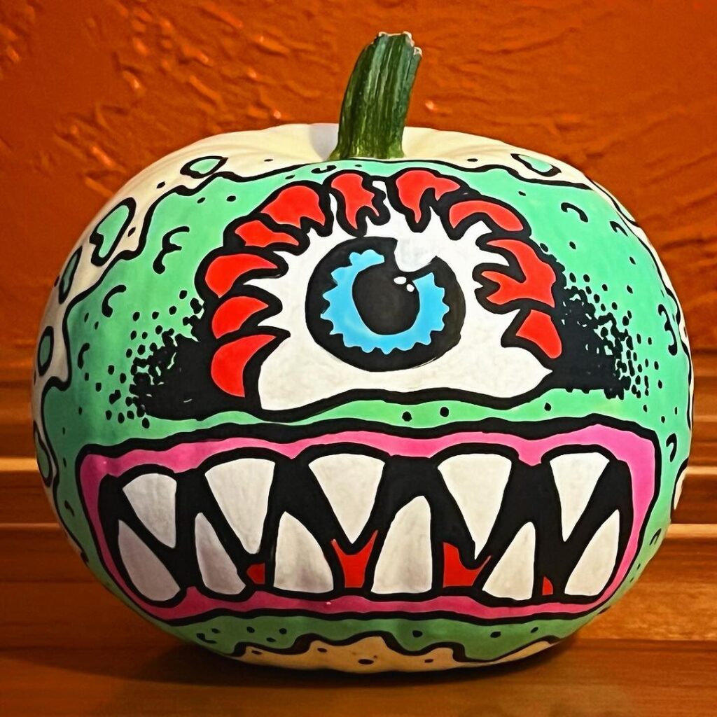Colorful monster face painted on pumpkin
