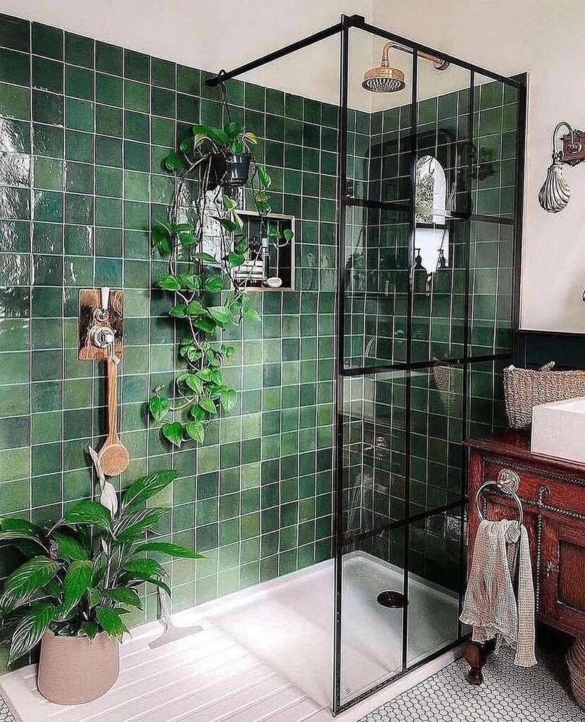 Green tiled bathroom with plants and black-framed shower