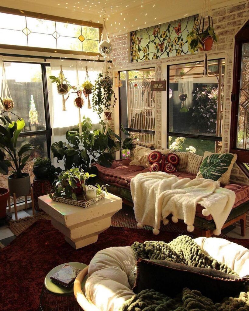 Sunlit room filled with plants cozy seating and stained glass