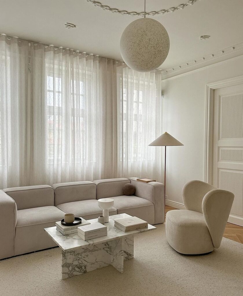 Minimalist living room with white decor and large round pendant light