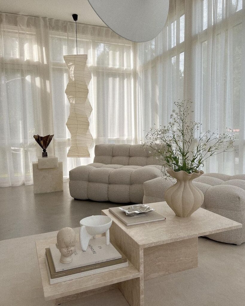 Bright minimalist living room with paper lantern and cozy seating.