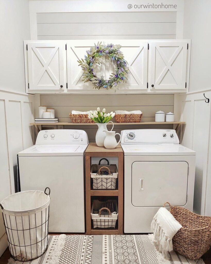 White farmhouse laundry room with floral decor and patterned rug.