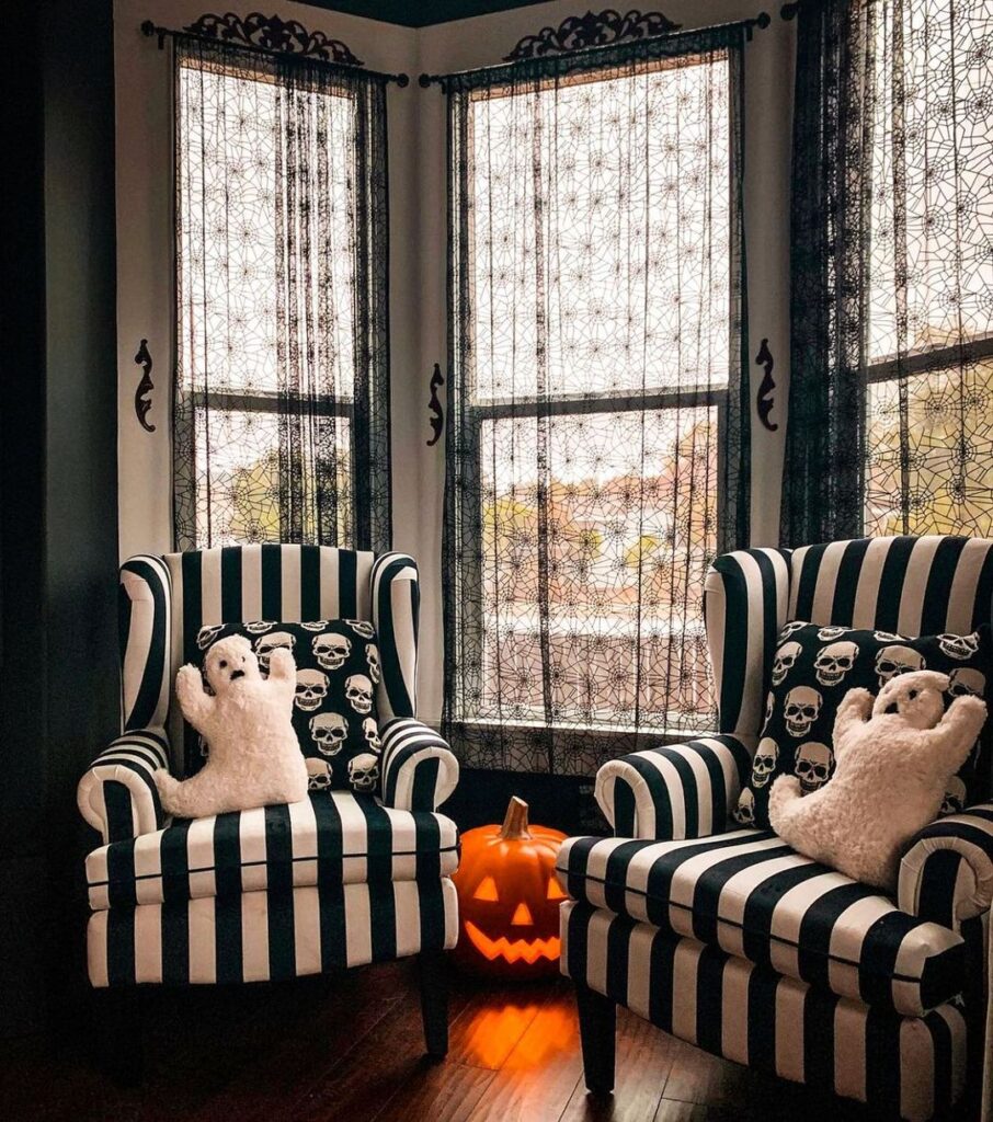 Halloween reading nook with striped chairs ghost pillows and spiderweb curtains