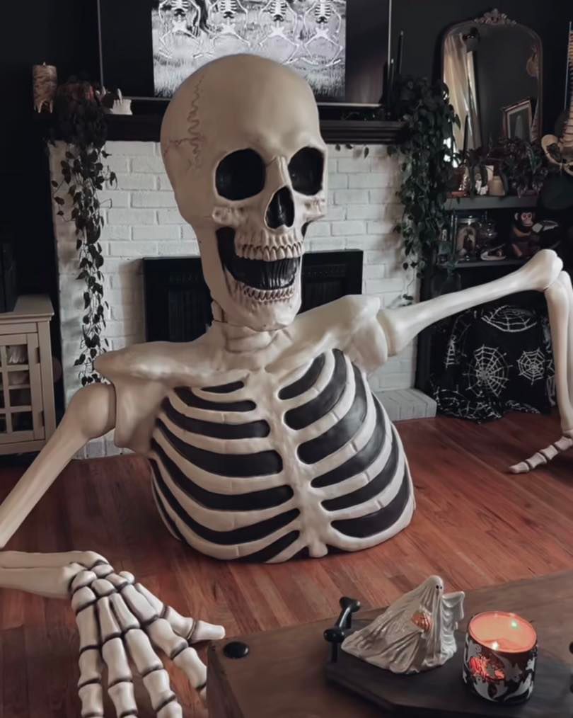 Huge skeleton decoration looms over fireplace scene