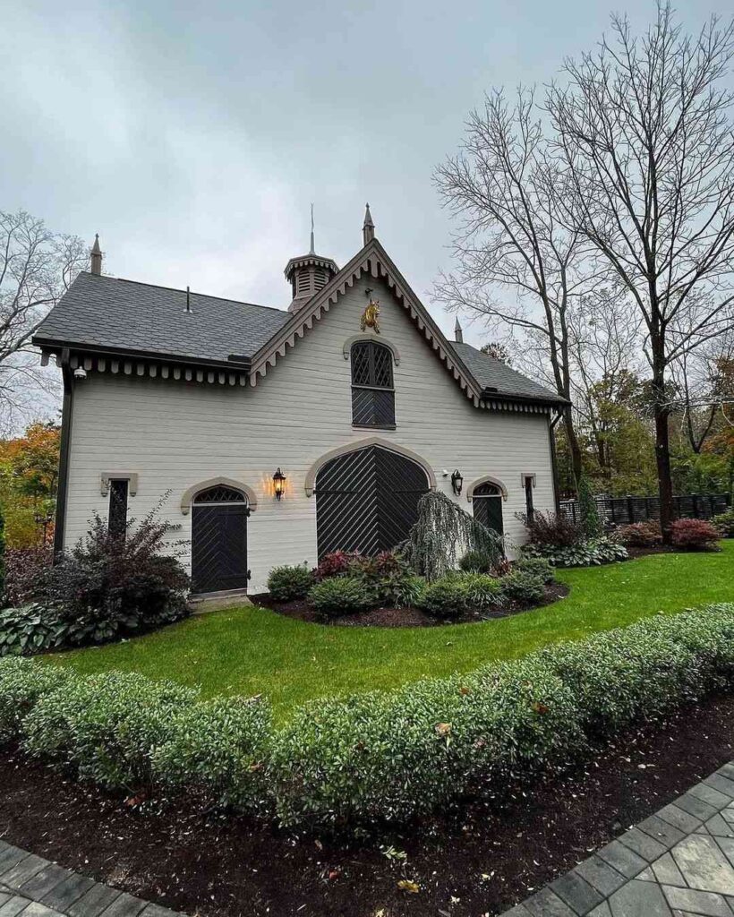 White Gothic carriage house with black trim and cupola